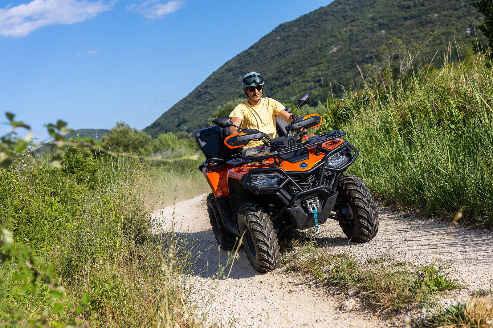 A rider on a gravel trail with the Konavle hills behind