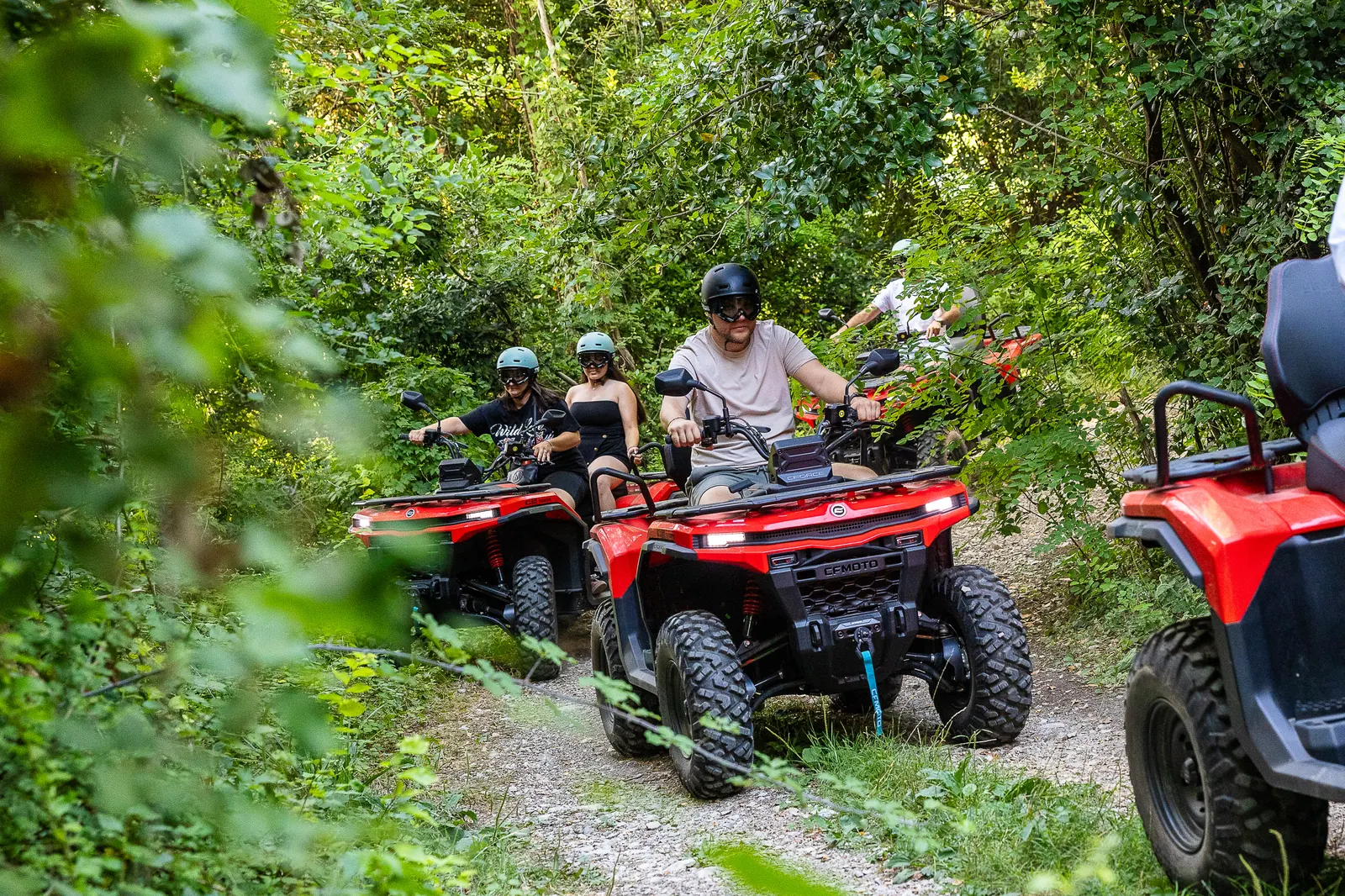 Convoy riding a shaded forest trail