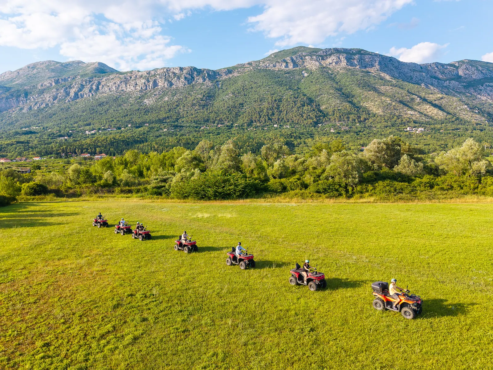 The convoy crossing an open field below the mountains