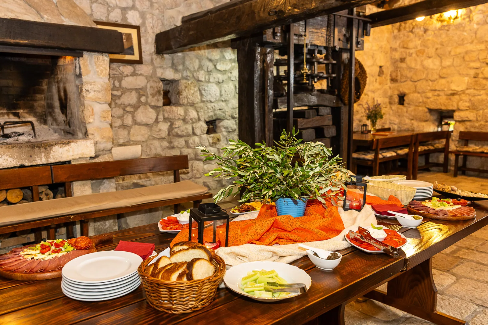 Long wooden table set with the tasting platter in the stone konoba